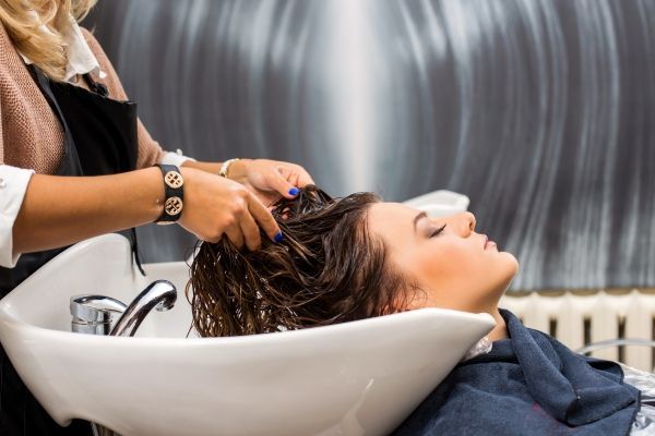 tratamiento para la hidratación del pelo - mujer en la peluquería recibiendo un tratamiento para hidratar su melena