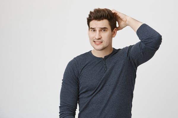 Hombre analizando las posibles causas de la caída del cabello, para revertir la situación y estimular el crecimiento capilar