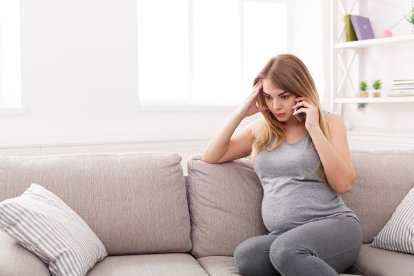 Se nos cae mucho el pelo - Mujer consultando por teléfono con un médico especialista sobre su caída de cabello anormal, la cual se debe a los cambios hormonales que genera el embarazo