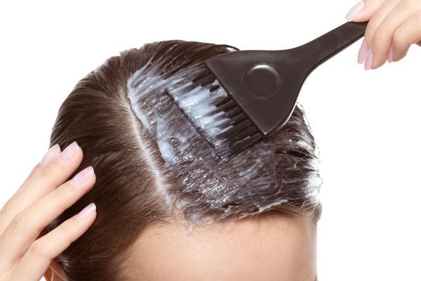 Mujer aplicando una crema antifúngica en el cabello, la cual permite matar las bacterias que causan la afección en el cuero cabelludo