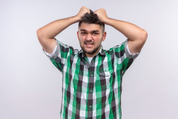 Injerto capilar infectado - Hombre abrumado por los dolores musculares que presenta en el cuello y la cabeza, luego de someterse a un implante de cabello