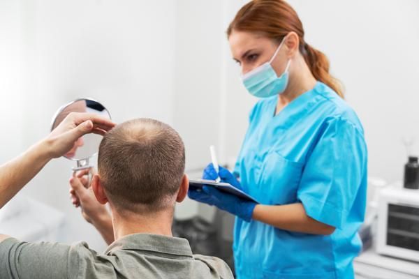 Precio del injerto capilar en la coronilla - Médico especialista evaluando si el paciente es apto para realizar el implante de cabello, el cual ya tiene definido el método que se utilizará