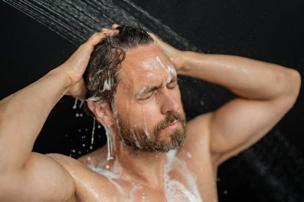 lavarse el cabello todos los días - hombre adulto bajo la ducha aclarando el champú de su cabeza