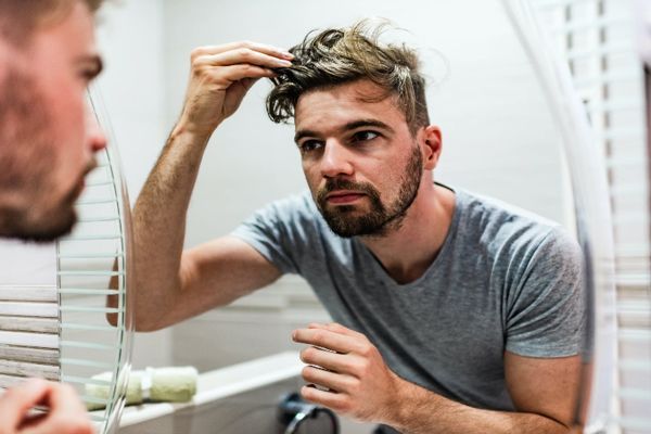 pica la cabeza - hombre delante del espejo revisando su cabello