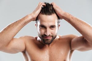 lavarse el cabello todos los días - hombre después de la ducha pasando sus manos por el cabello mojado