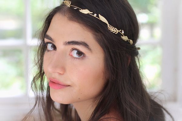 mujer joven con el pelo largo llevando una diadema metálica con formas de hojas