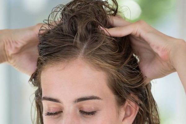 duele el cabello - mujer realizándose un masaje en el cuero cabelludo para mejorar la circulación