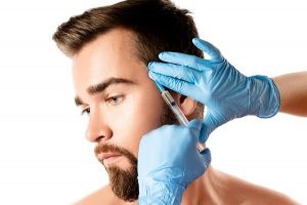 mesoterapia capilar - hombre recibiendo una inyección de mano de la especialista en la zona de las patillas