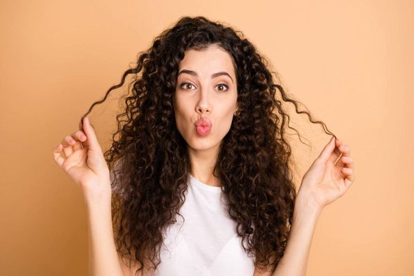 mujer con el pelo rizado mandando un beso a la camara