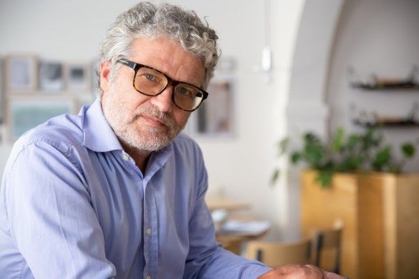 hombre con canas en la cabeza y en la barba en el salón de su casa