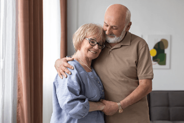 Cómo envejece nuestro pelo - pareja de personas mayores abrazadas y con cara de felicidad