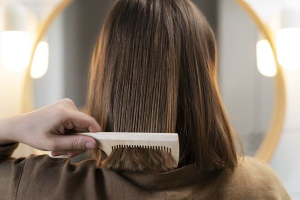 Keratina para el pelo - Mujer en un salón de belleza con su cabello liso luego del tratamiento de keratina