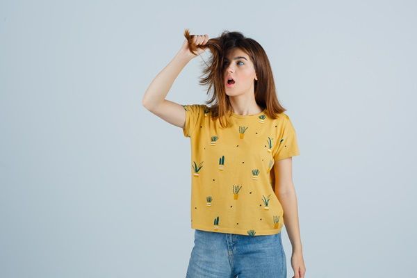 Revitalizar el pelo después del verano - Mujer triste por el daño que recibió su cabello en vacaciones