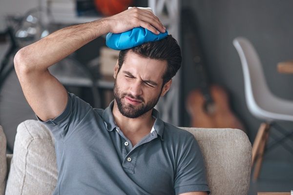 Zona donante - Hombre colocando una compresa fría en la cabeza para bajar la hinchazón, luego del injerto de cabello