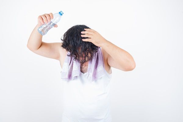 Hombre lavando su cabello con agua dulce para quitar residuos de cloro y salitre