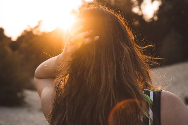 Revitalizar el pelo después del verano - Rayos UV del sol impactando directamente sobre el cabello de una mujer