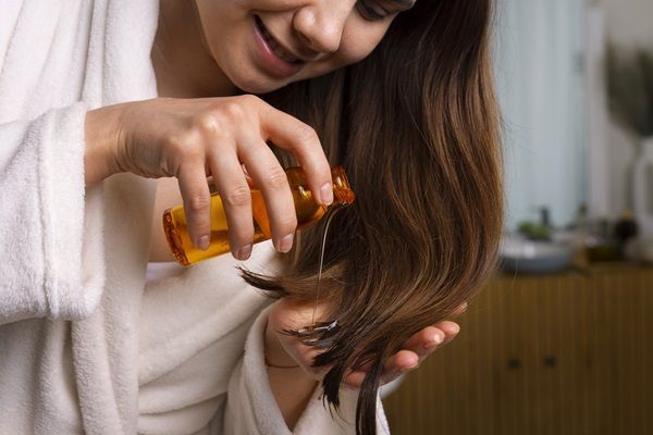 Mujer aplicando un producto capilar para nutrir su cabello