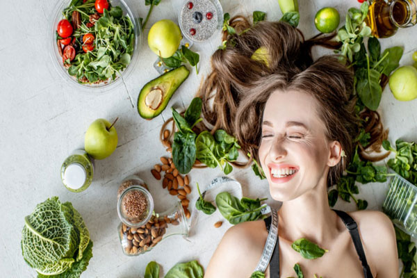 Chica visiblemente sonriente disfruta de los beneficios de comer vegetales de hoja verde y alimentos ricos en antioxidantes