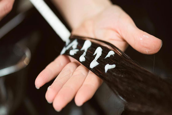 Botox capilar - Aplicación de tratamiento hidratante por mechones en el cabello de una cliente