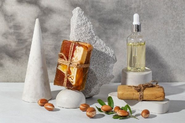 Aceite de argán para el pelo - Recipiente con aceite y varias semillas de argán que ayudan a nutrir el cabello