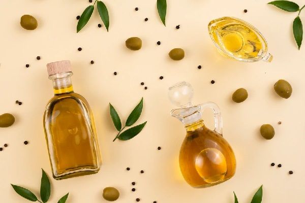 Aceite de oliva - Recipientes con aceite y varias aceitunas verdes que ayudan a hidratar el cabello gracias a sus propiedades nutritivas
