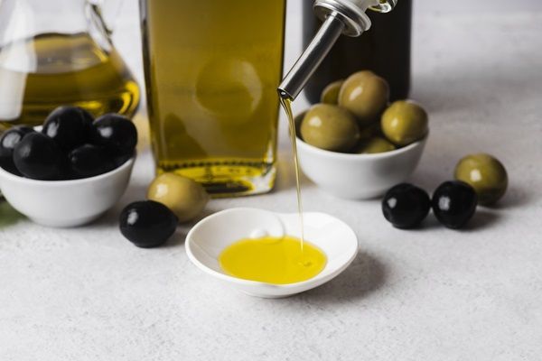 Persona colocando el líquido de las aceitunas en un recipiente para hacer una mascarilla capilar