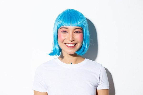 Cortes de pelo para cara redonda - Mujer feliz con su cabello en color azul y corte hasta la barbilla, lo cual estiliza su cara redonda