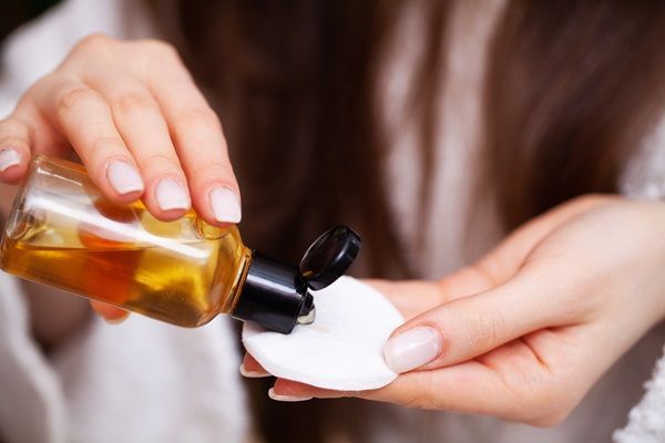 Mujer colocando aceite nutritivo en una esponja para hidratar y revitalizar su cabello