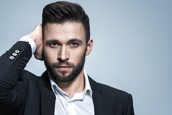 Hombro posando con un corte de cabello estilo Pompadour, que brinda un toque de elegancia a su rostro