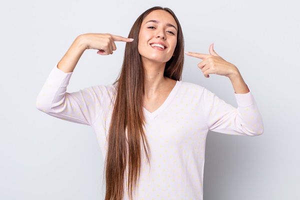 Mujer posando feliz con su cabello largo y saludable gracias a los consejos de crecimiento capilar