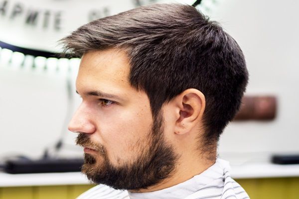 Hombre con corte de tupé y barba que ayuda a estilizar su rostro redondo