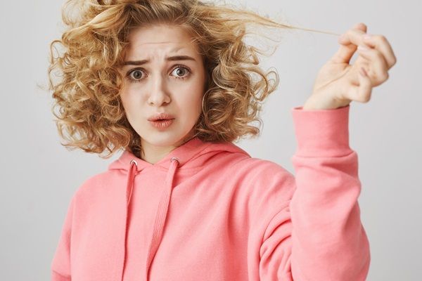 Bioplastia capilar - Mujer abrumada por tener su cabello reseco y con frizz por no hacer el tratamiento de bioplastia