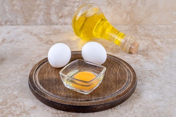 Recipiente con líquido extraído de las aceitunas y huevos, para hacer una mascarilla capilar que hidrata y nutre el cabello