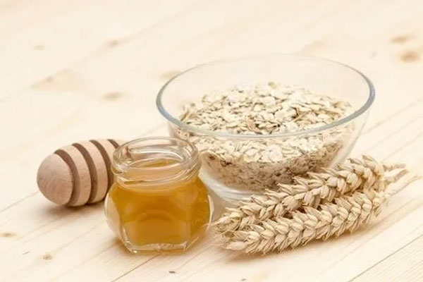 Exfoliantes capilares - Tazón de vidrio con hojuelas de avena y miel para preparar una mezcla