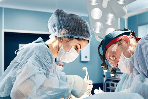 Médicos cirujanos trabajan en la remoción de un tumor benigno 