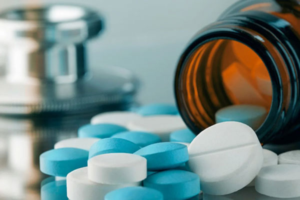 Hemangioma capilar - Frasco de pastillas de vidrio con medicamentos desbordados sobre una mesa 