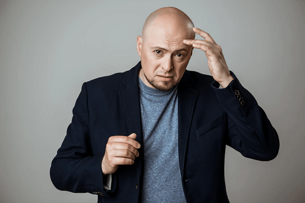 Caries y calvicie - Imagen de un hombre con alopecia avanzada, en referencia a que las caries en los dientes pueden hacer caer el cabello
