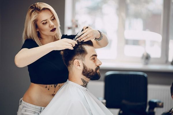 Hombres con entradas - Estilista realizando un corte de cabello a un hombre, para resaltar sus rasgos físicos y disimular las entradas