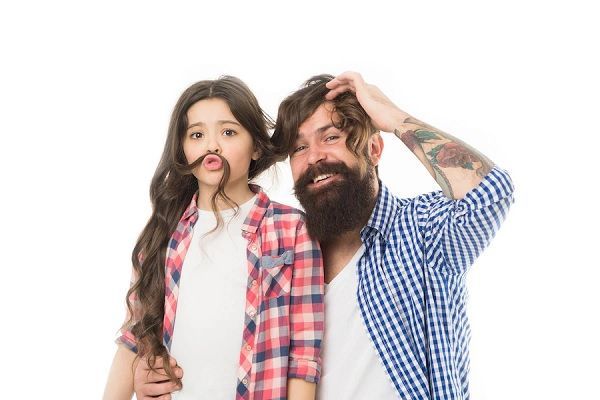 densidad del pelo fino - padre e hija posando juntos, el padre aprovecha el pelo de su hija para taparse la cabeza