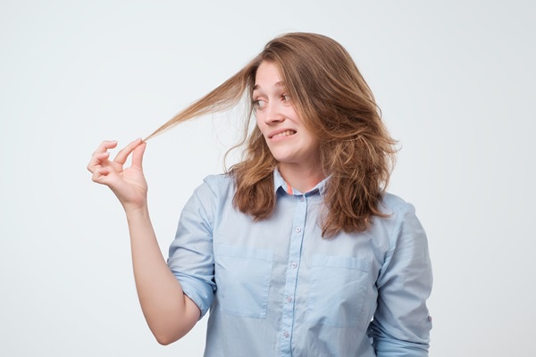 Tricofagia - Mujer sujetando su cabello con intenciones de comerlo, debido al trastorno que posee llamado tricofagia