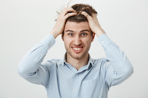 Tricotilomanía - Hombre con exceso de estrés sufriendo de tricotilomanía, ya que arrancar el cabello lo ayuda a aliviar los síntomas y la ansiedad
