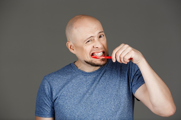 Caries y calvicie - Hombre cepillando sus dientes para prevenir las caries, ya que pueden ocasionar mayor pérdida de cabello con la alopecia areata