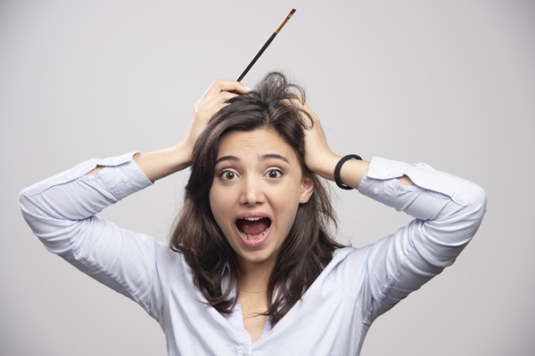 Mujer joven sufriendo del trastorno que la lleva a arrancarse el cabello, debido problemas de estrés y ansiedad