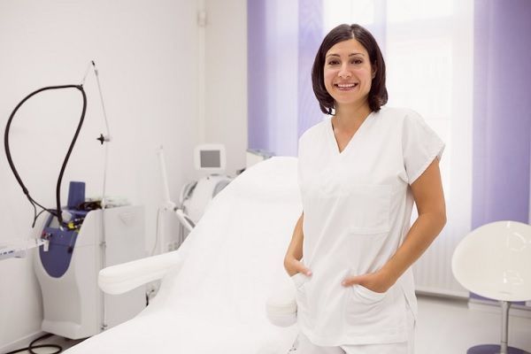 Dermatólogo en el injerto capilar - Esteticista y especialista en el cuidado de la piel se muestra orgullosa en las instalaciones de su clínica 