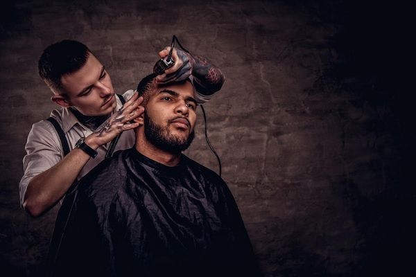 Pelo tras injerto capilar - Barbero cortando el cabello de un hombre con mucho cuidado, luego de varios meses del implante capilar