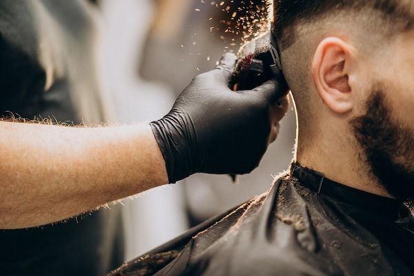 Pelo tras injerto capilar - Barbero cortando el cabello de un hombre con una máquina de afeitar, luego de pasar más de 5 meses desde el implante de pelo