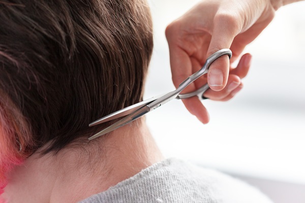 Pelo tras injerto capilar - Estilista cortando el cabello de un hombre con una tijera, luego de 3 meses desde que se realizó el implante capilar