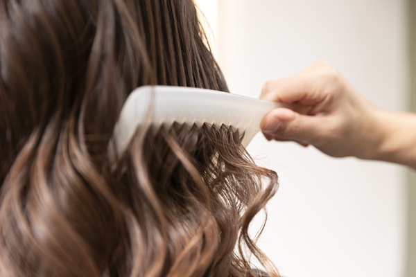 Vinagre de manzana - Mujer peinando su cabello luego de aplicarse el vinagre de manzana, el cual ayuda a fortalecer las hebras capilares