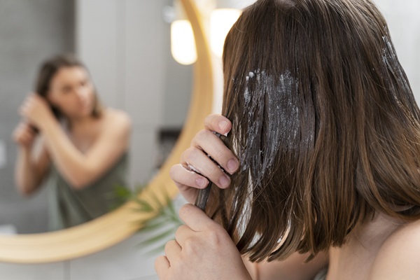 Mujer aplicando una mascarilla capilar que ayuda a aclarar el pelo, gracias a las propiedades ácidas que posee