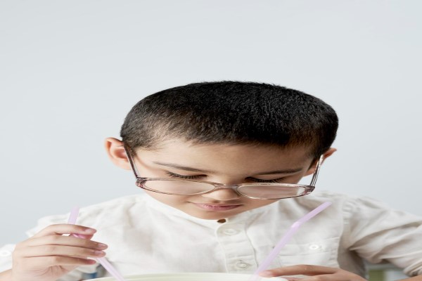 alopecia en niños - niño sentado mirando un cuenco con dos pajitas